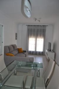 un soggiorno con divano e tavolo in vetro di Vandelvira a Baeza