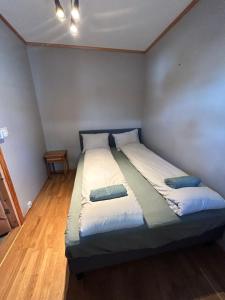 a bedroom with a bed with two pillows on it at Cozy Scandinavian apartment central in Oslo - free parking and close to many amenities in Grorud