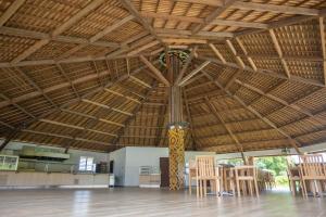 MacouriaにあるHôtel Belle Terre Resortの木製の天井、テーブルと椅子が備わる客室です。