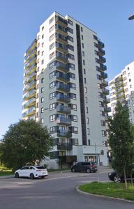 un grand immeuble avec des voitures garées dans un parking dans l'établissement Bright 3-room apartment in Mustamäe, à Tallinn