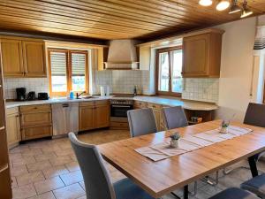 a large kitchen with a wooden table and chairs at ~ Straubings grosses Apartment~ in Schambach