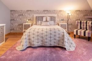 um quarto com uma cama grande e um tapete roxo em Chalet Miranda. VV-1595-AS em Avilés