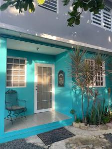a blue house with a chair in front of it at Beach Front Apartments Seven Seas in Fajardo