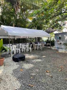 a tent with white chairs and tables and chairs at Beach Front Apartments Seven Seas in Fajardo