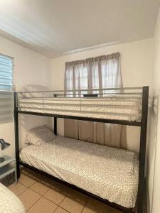 two bunk beds in a room with a window at Beach Front Apartments Seven Seas in Fajardo
