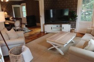 a living room with a flat screen tv and a coffee table at Hillside Haven: Luxe Farm Escape - 5BR-2 King Beds in Swanzey