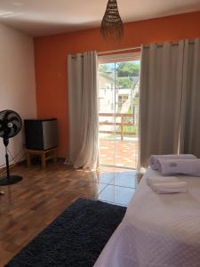 Schlafzimmer mit einem Bett und einer Glasschiebetür in der Unterkunft Cruzeiro in São Pedro da Aldeia