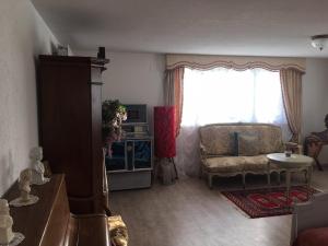 a living room with a couch and a window at Double room in nice house near the forest (basement floor) in Brügg