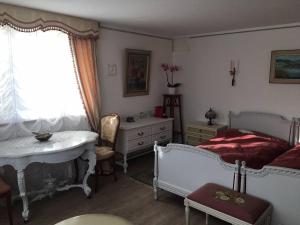 1 dormitorio con 2 camas, mesa y ventana en Double room in nice house near the forest (basement floor) en Brügg