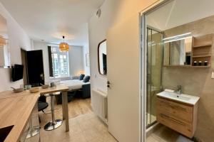 a bathroom with a sink and a shower in a room at Rive Gauche - Studio Trouville in Trouville-sur-Mer