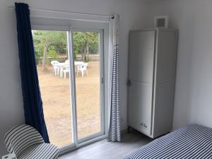 ein Raum mit einer Glasschiebetür und einem Tisch draußen in der Unterkunft La maison bleue in Barneville-Carteret