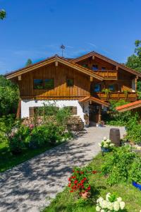 ein großes Holzhaus mit einem Weg davor in der Unterkunft Haus Kilian in Berchtesgaden