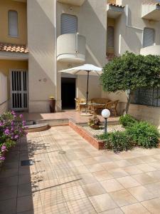 a courtyard with a table and an umbrella in a building at A... Mare Sicilia in Marina di Modica +16 photos