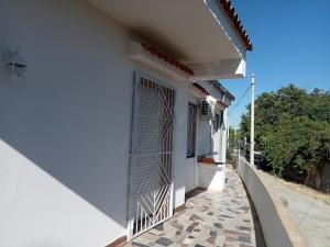 una casa blanca con una puerta en una calle en Casa vacanze da sogno, en SantʼAlfano