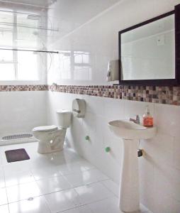 Baño blanco con aseo y lavamanos en Roma Lodges House- Campin Simón Bolivar Movistar Embajada compensar, en Bogotá