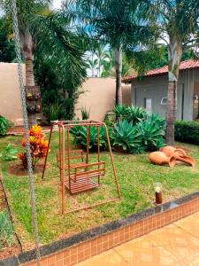 a swing in a yard with palm trees at Casa de Campo com Wi-Fi churrasq e piscina em MG in Lagoa Santa +10 photos