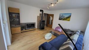 a living room with a blue couch and a tv at Ferienwohnung Mein Zuhause in Pottenstein +14 photos