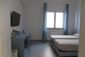 Habitación con 2 camas, escritorio y ventana. en Marea, en Messina