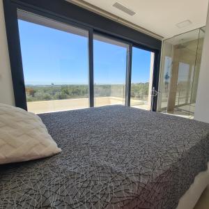 a bedroom with a bed and a large window at The Panoramic Penthouse in Orihuela