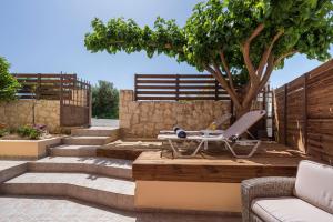 une terrasse avec une table, un arbre et des escaliers. dans l'établissement Anna Boutique Apartment, à Kato Daratso