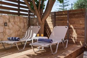 two chairs on a deck with a tree at Anna Boutique Apartment in Kato Daratso