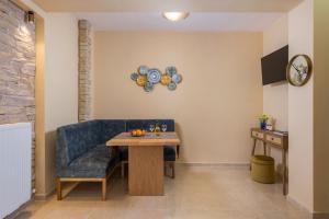 un salon avec une table et un canapé bleu dans l'établissement Anna Boutique Apartment, à Kato Daratso