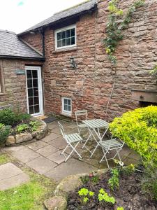 two chairs and a table in front of a building at Windale at Wetheral Cottages in Great Salkeld
