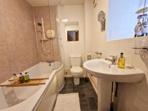 a bathroom with a sink and a tub and a toilet at Windale at Wetheral Cottages in Great Salkeld