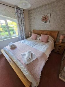 a bedroom with a large bed with towels on it at Windale at Wetheral Cottages in Great Salkeld