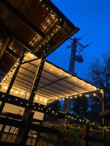 a pergola with lights on it at night at Casa ARRA in Bran