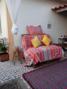 um quarto com uma cama com duas almofadas amarelas em Caparica Holidays em Charneca