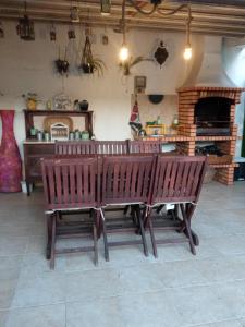 dwie drewniane ławki siedzące w pokoju z kominkiem w obiekcie Caparica Holidays w mieście Charneca