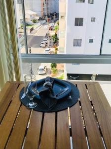 a hat and a glass on a table with a window at Apartamento Praia de Porto Belo, Balneario Pereque, SC in Porto Belo