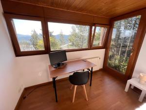 a computer desk in a tiny house with windows at Chalet Triplex aux Angles vue sur le lac et au pied des pistes in Les Angles