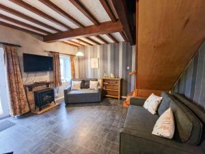 a living room with a couch and a fireplace at Mickledale at Wetheral Cottages in Great Salkeld