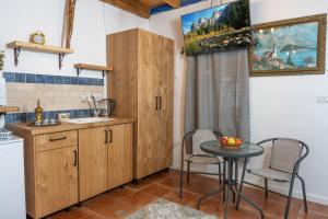 a kitchen with wooden cabinets and a table and a sink at לומינוס האגוז in Ḥurfeish