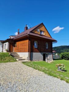 a house on a hill with a gravel driveway at Lochówka - zaciszny domek w górach in Krynica Zdrój
