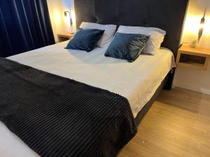 a large bed with two blue pillows on it at Apartman Ena Fojnica in Fojnica