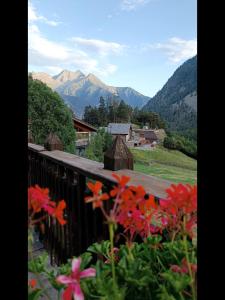 a balcony with a view of mountains and flowers at Casa Nemesis in Brusson