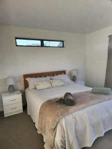 a bedroom with a bed with a hat on it at Oceanside Haven in Ohope Beach