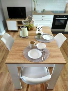una mesa de madera con tazas y platillos en la cocina en Ortegal Beach & Seacliffs, en Cariño