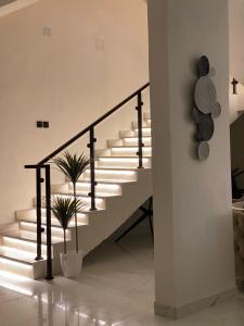 eine Treppe in einem Haus mit Lichtern an der Wand in der Unterkunft شاليه اند هوم in Ha'il