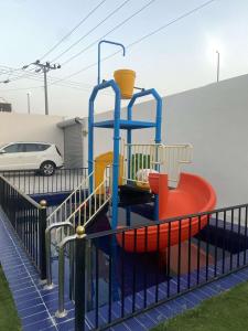 a playground with a slide in a parking lot at شاليه اند هوم in Hail