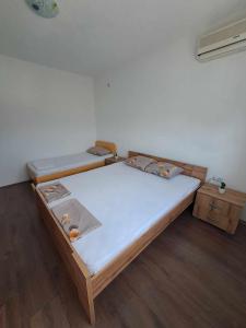 two beds in a room with wooden floors at Lazarov Apartments in Nov Dojran