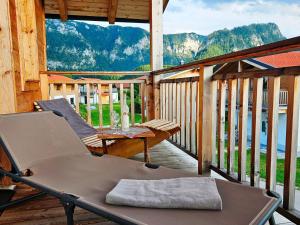 a porch with two chairs and a table on a deck at Apartment with sauna and panoramic view in Inzell in Inzell