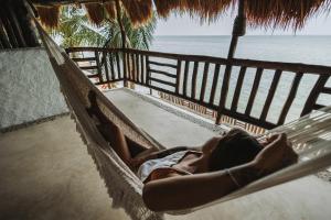 una mujer tendida en una hamaca con vistas al océano en Las Nubes de Holbox, en Isla Holbox