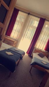 two beds sitting in a room with windows at Willa nad Potokiem in Zakopane