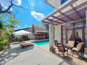 kuta 5BR private villa pool ,near airport, في كوتا: فناء مع كراسي ومسبح