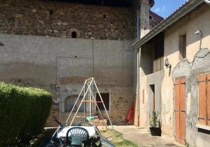 uma escada sentada ao lado de um edifício em Dormez dans la chambre du meunier ! em Germolles-sur-Grosne