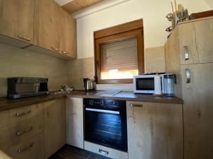 a kitchen with a stove and a microwave on a counter at Srce Zminice in Žabljak
